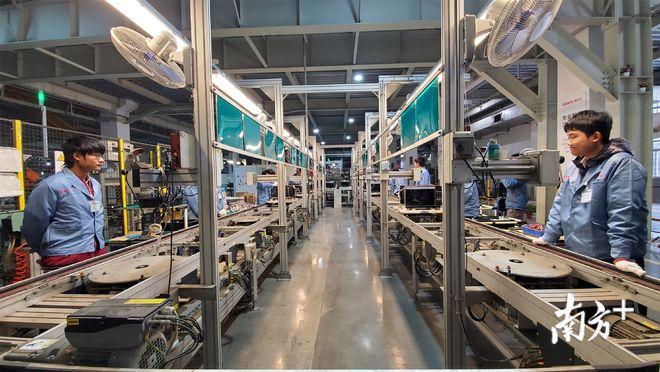 在格兰仕中山基地电子元件制造部车间,416名工人正与机器手密切配合.